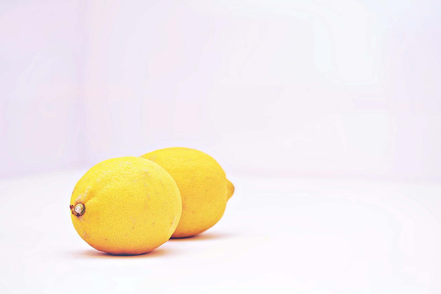 Limoni vibranti su sfondo bianco minimalista, simbolo di freschezza e novità