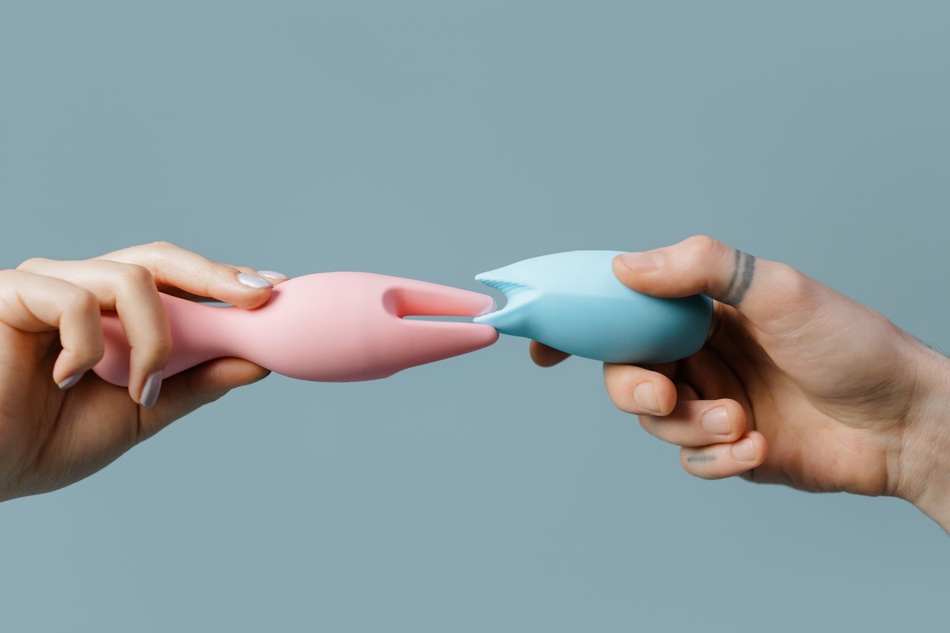 Hands holding colorful silicone vibrators, representing a fresh start with adult toys