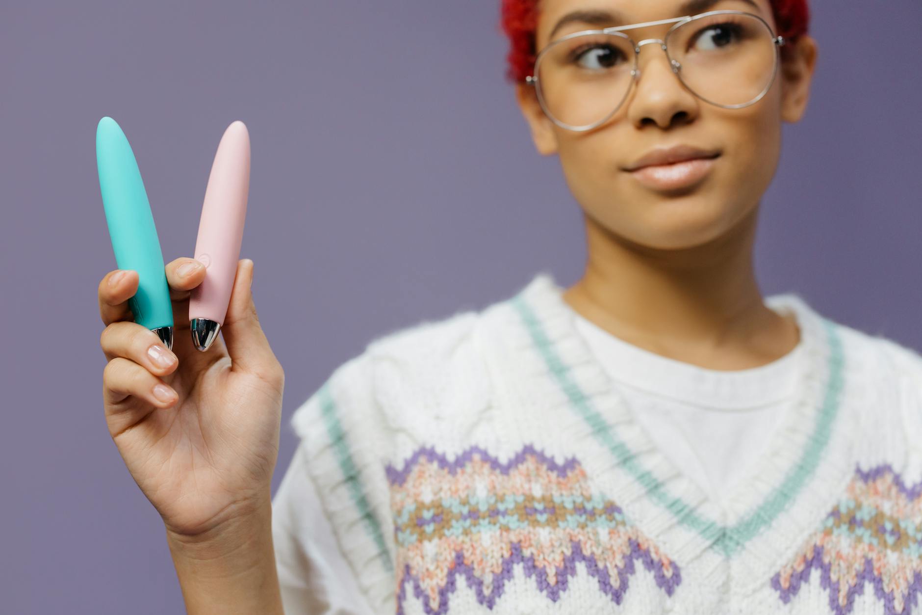 Hands holding colorful vibrators, representing pleasure and self-care