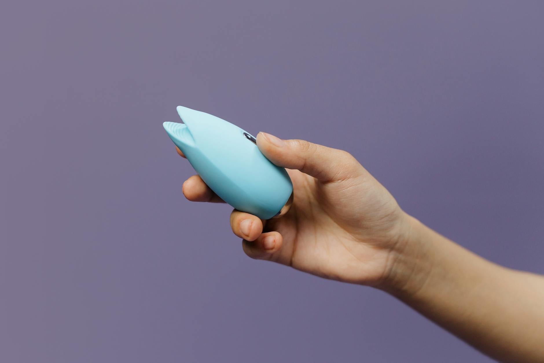 A blue silicone vibrator held in hand, symbolizing self-pleasure and body reclamation