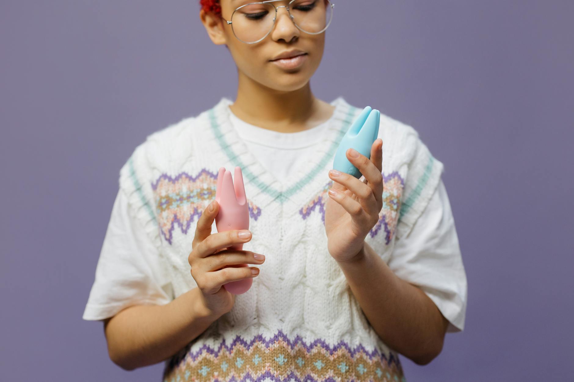 A young couple standing together indoors, holding a blue vibrator, symbolizing modern intimacy and reconnection.