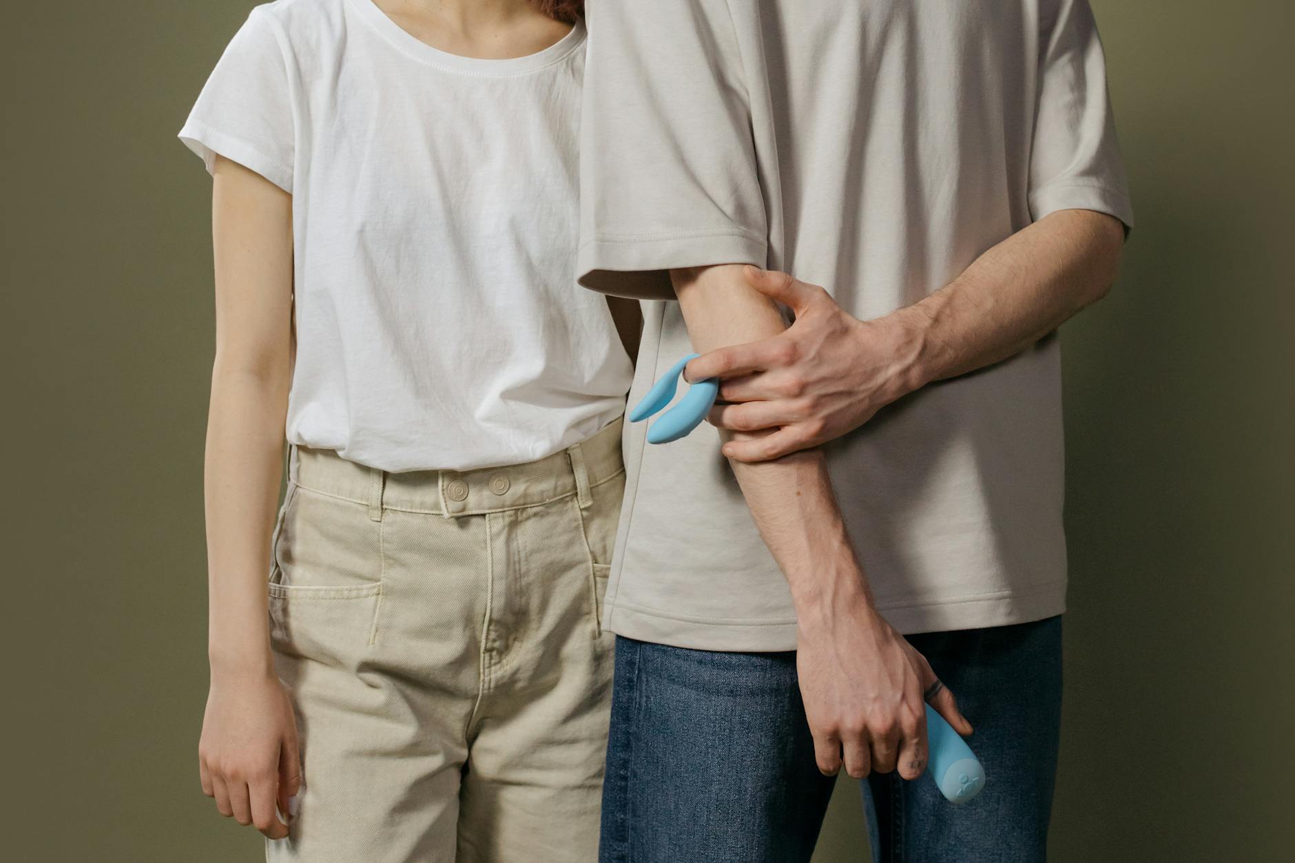 A couple holding a vibrator together, showing vulnerability and shared intimacy without rush